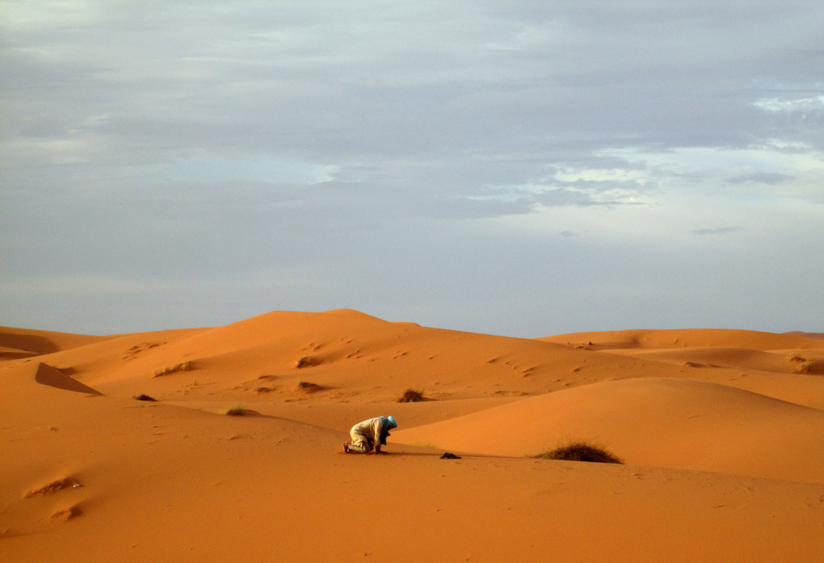 One of our guides stopping to pray in the desert Sahara Merzouga Morocco